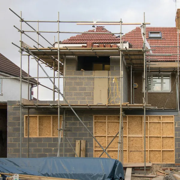 House extension under construction, wrapped in scaffolding
