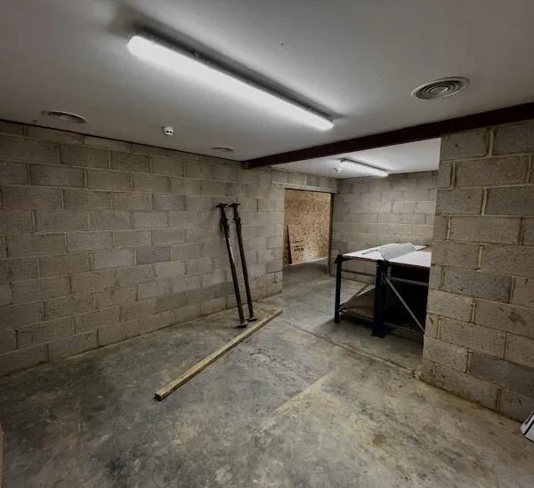 A bare blockwork room before plastering, with props leaning against the wall