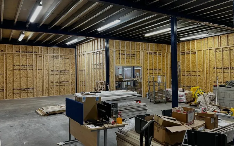 New rooms framed and sheathed in OSB under a warehouse mezzanine in Dartford, part way through the fit-out