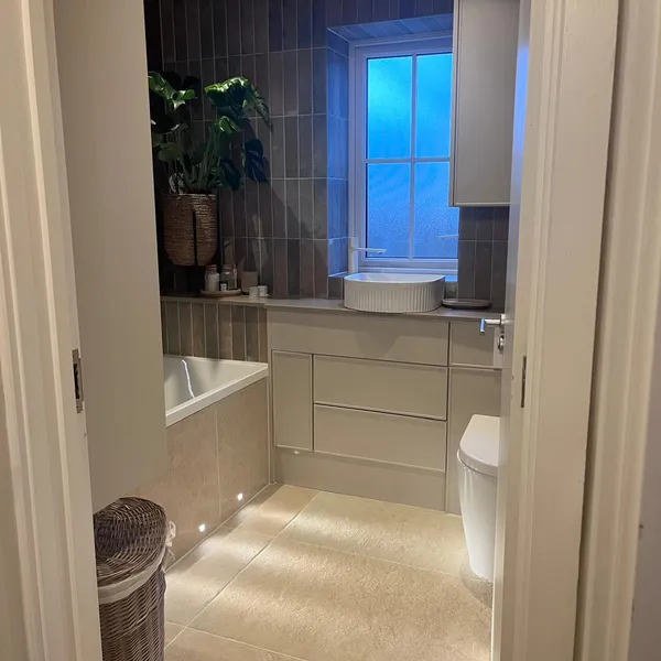 View into the finished family bathroom from the doorway, with low lights along the bath panel