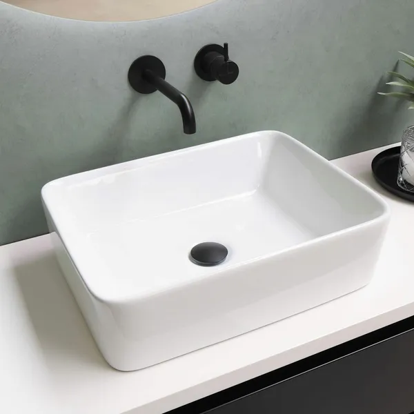 White rectangular counter-top basin with black wall-mounted taps