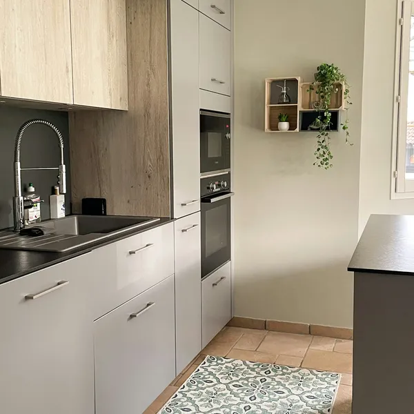 Pale kitchen with wall units, open shelving and a patterned tiled floor