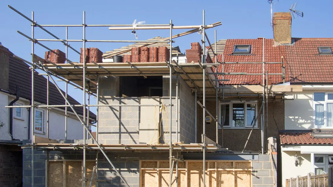 Rear house extension under construction, with timber framing and scaffolding