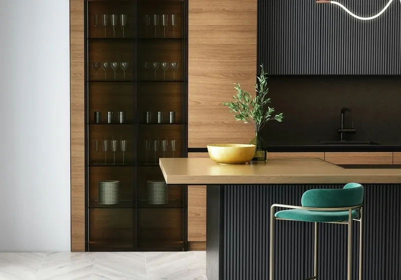 Modern kitchen with dark timber cabinetry, a dining table and a green upholstered chair