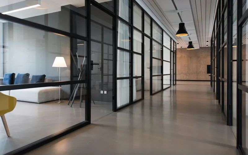Office corridor with glazed partitions and pendant lighting