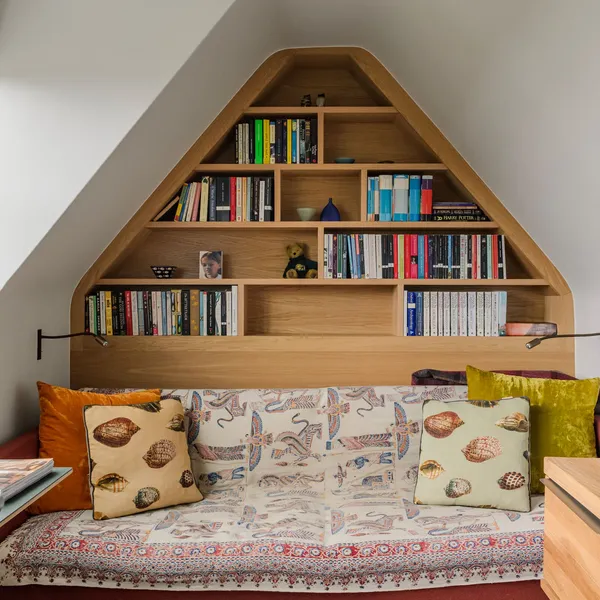 Study with a gable-shaped oak bookcase built around a daybed